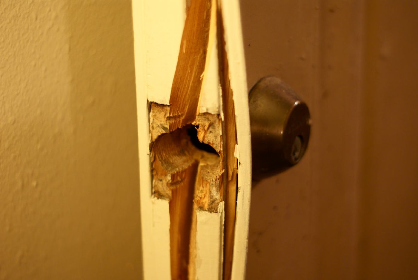 Close-up of a regular door split apart by a forceful kick